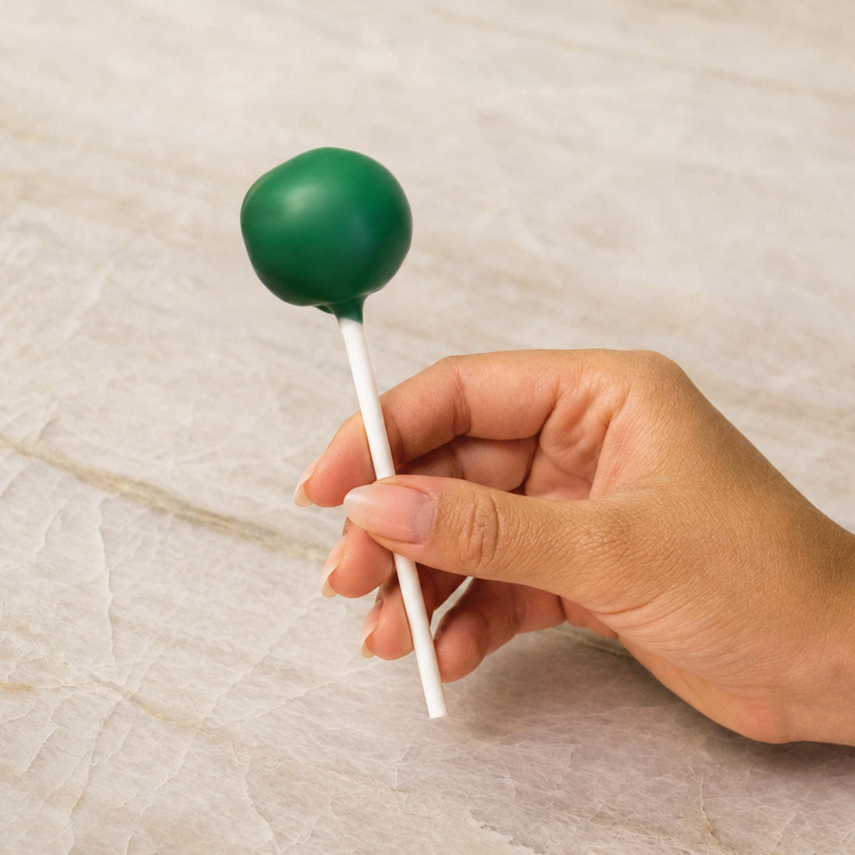 Green chocolate-coated cake pop made with natural food coloring powder.