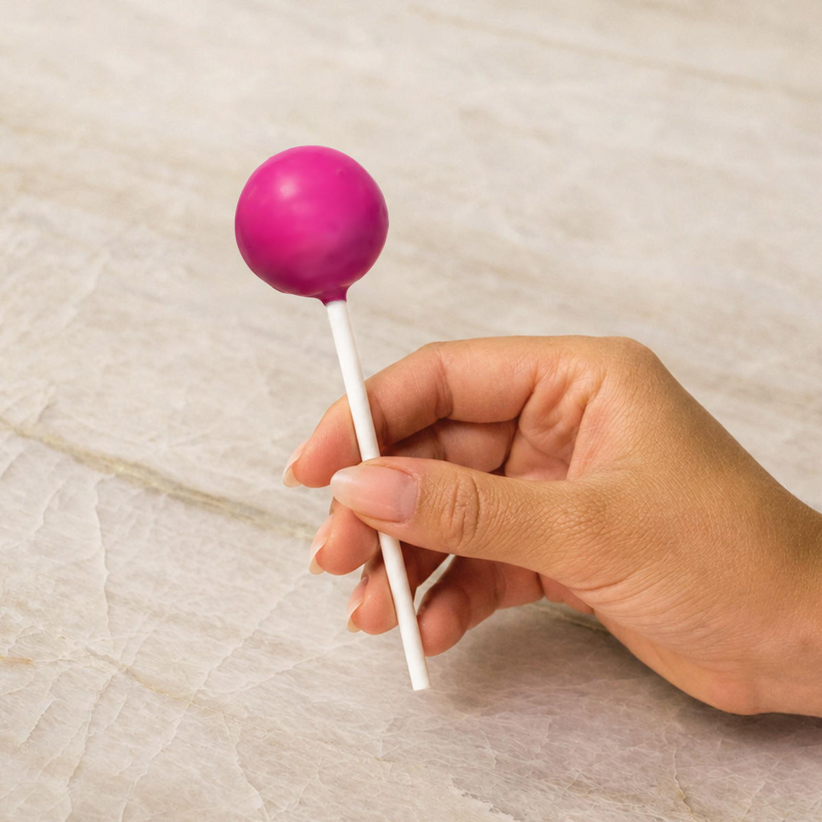 Pink chocolate-coated cake pop made with natural food coloring powder.