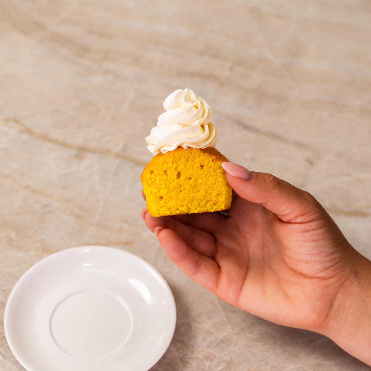 Yellow cupcake made with natural food coloring powder with white frosting.