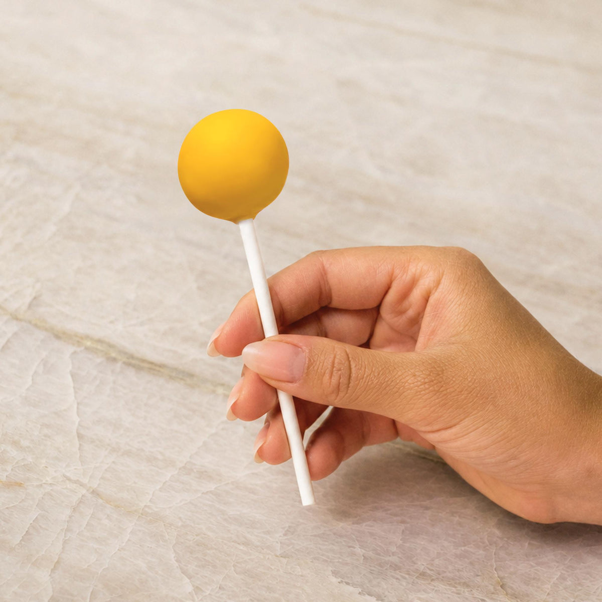 Yellow chocolate-coated cake pop made with natural food coloring powder.