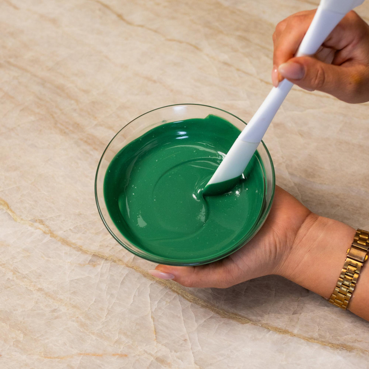 Green chocolate mixed with natural food coloring powder in a bowl.