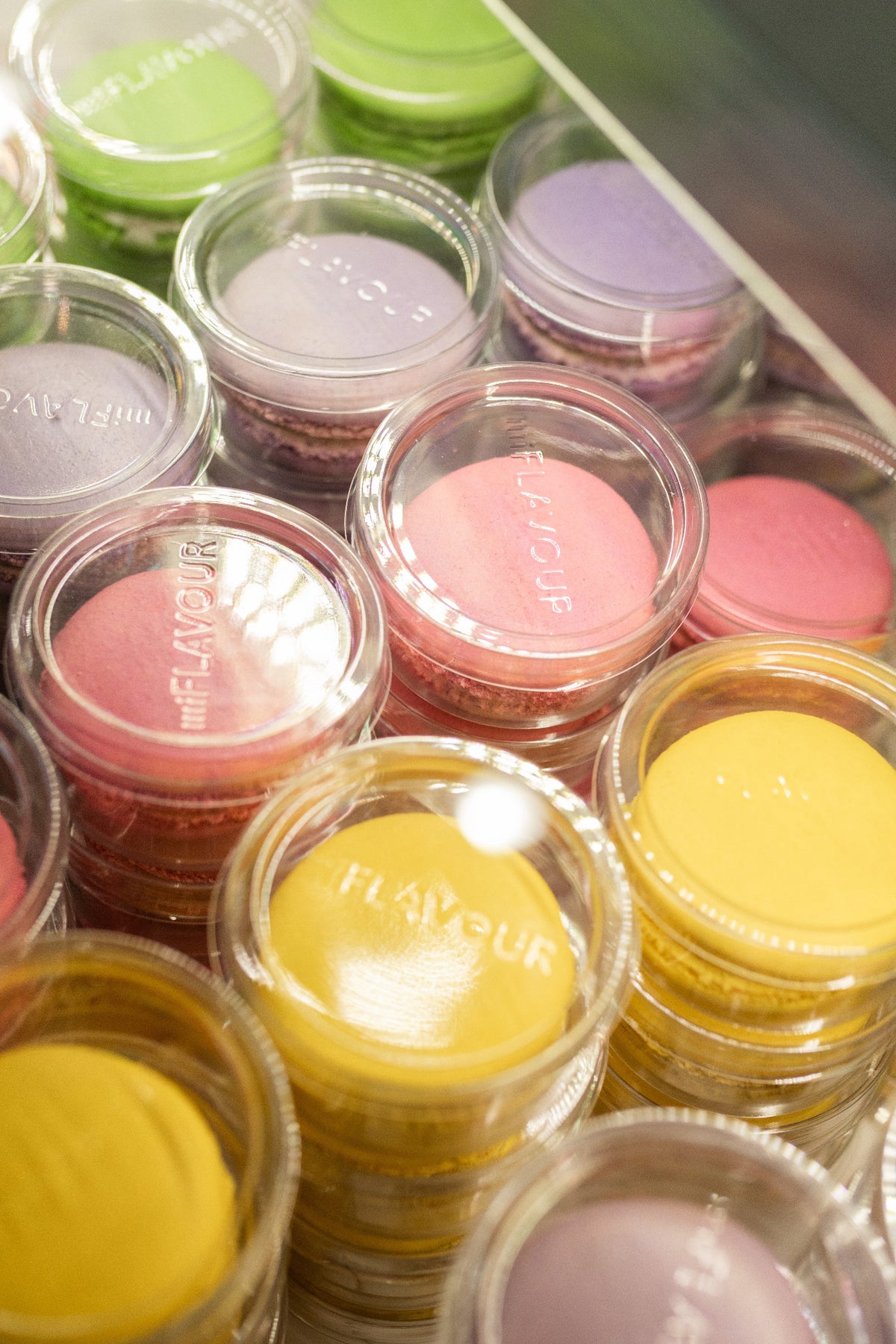 Pink and yellow macarons made with ADAMA natural food coloring packaged for bakery retail.
