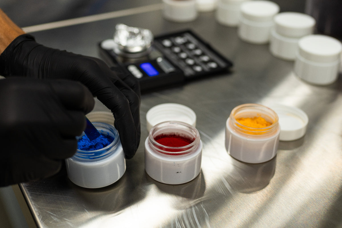 ADAMA natural food coloring powders prepared for testing beside a digital scale.