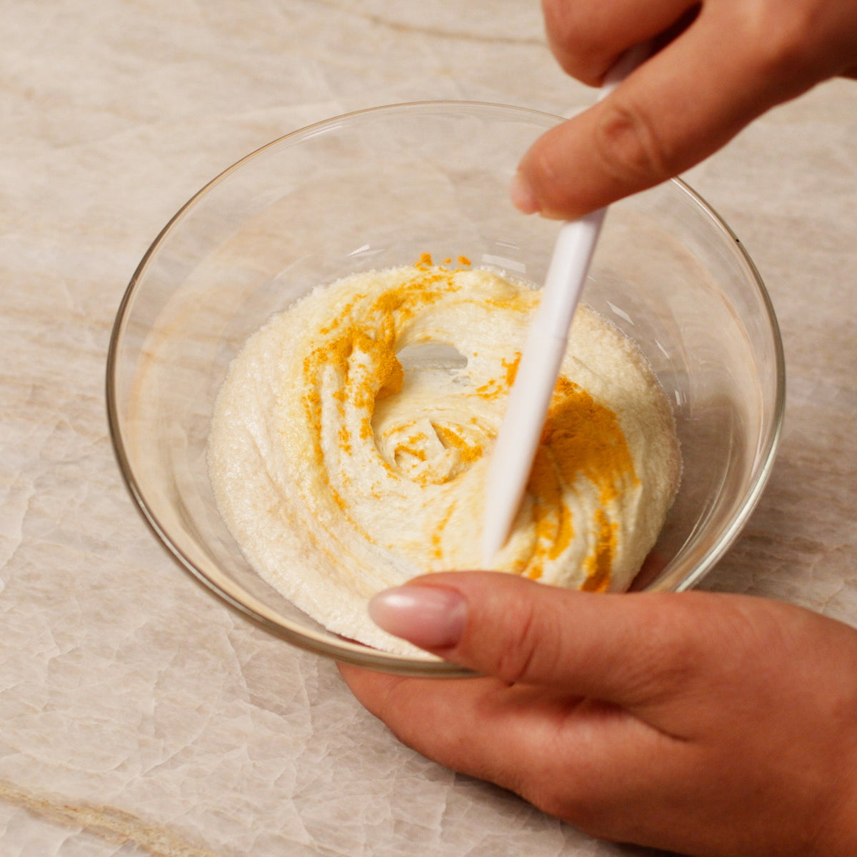 Orange ADAMA natural food coloring powder being mixed into cake batter.