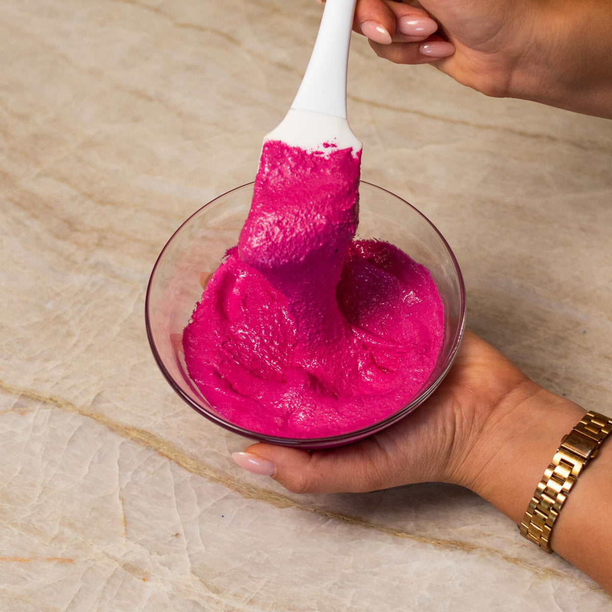 Pink macaron batter mixed with natural food coloring powder in a bowl.