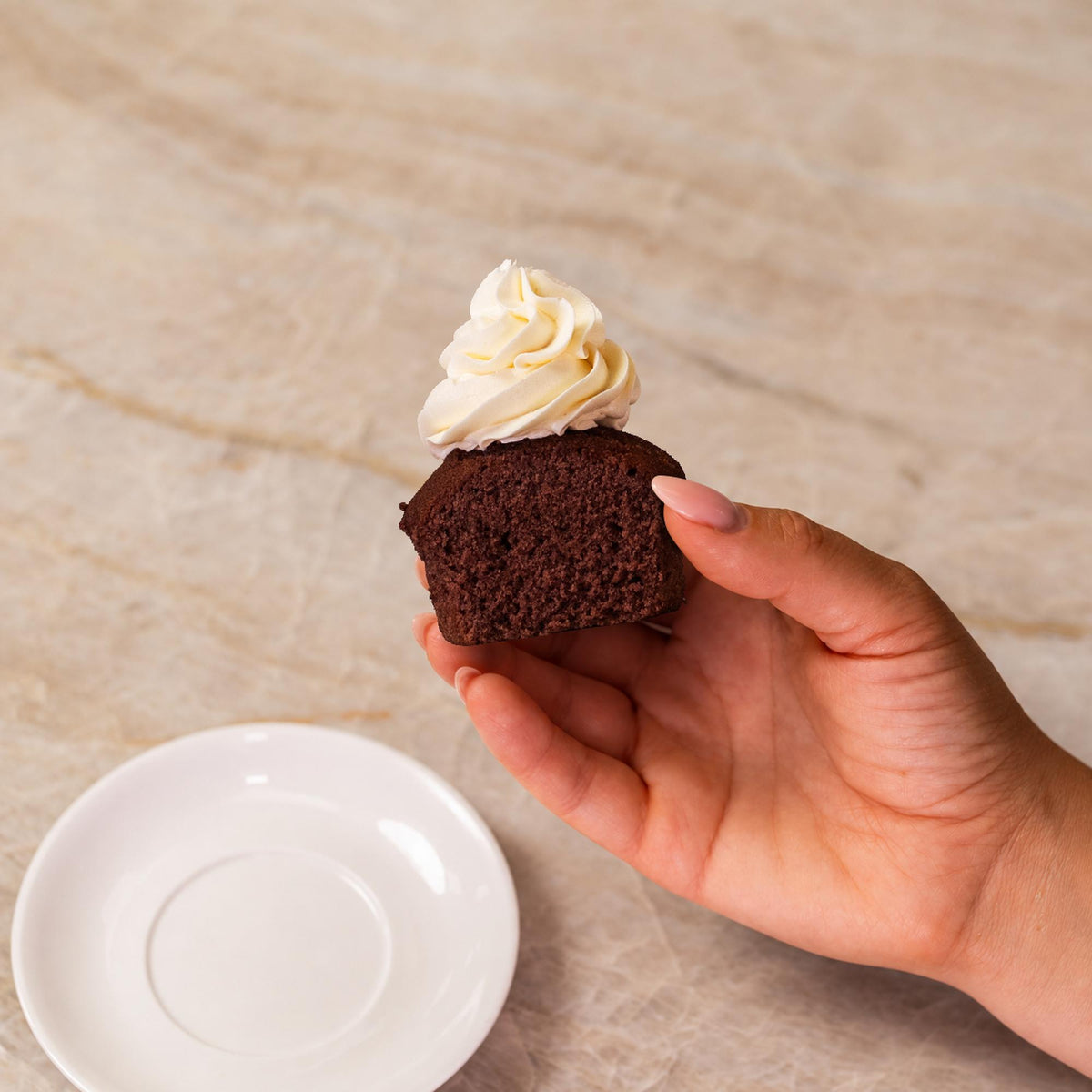Brown cupcake made with natural food coloring powder with white frosting.