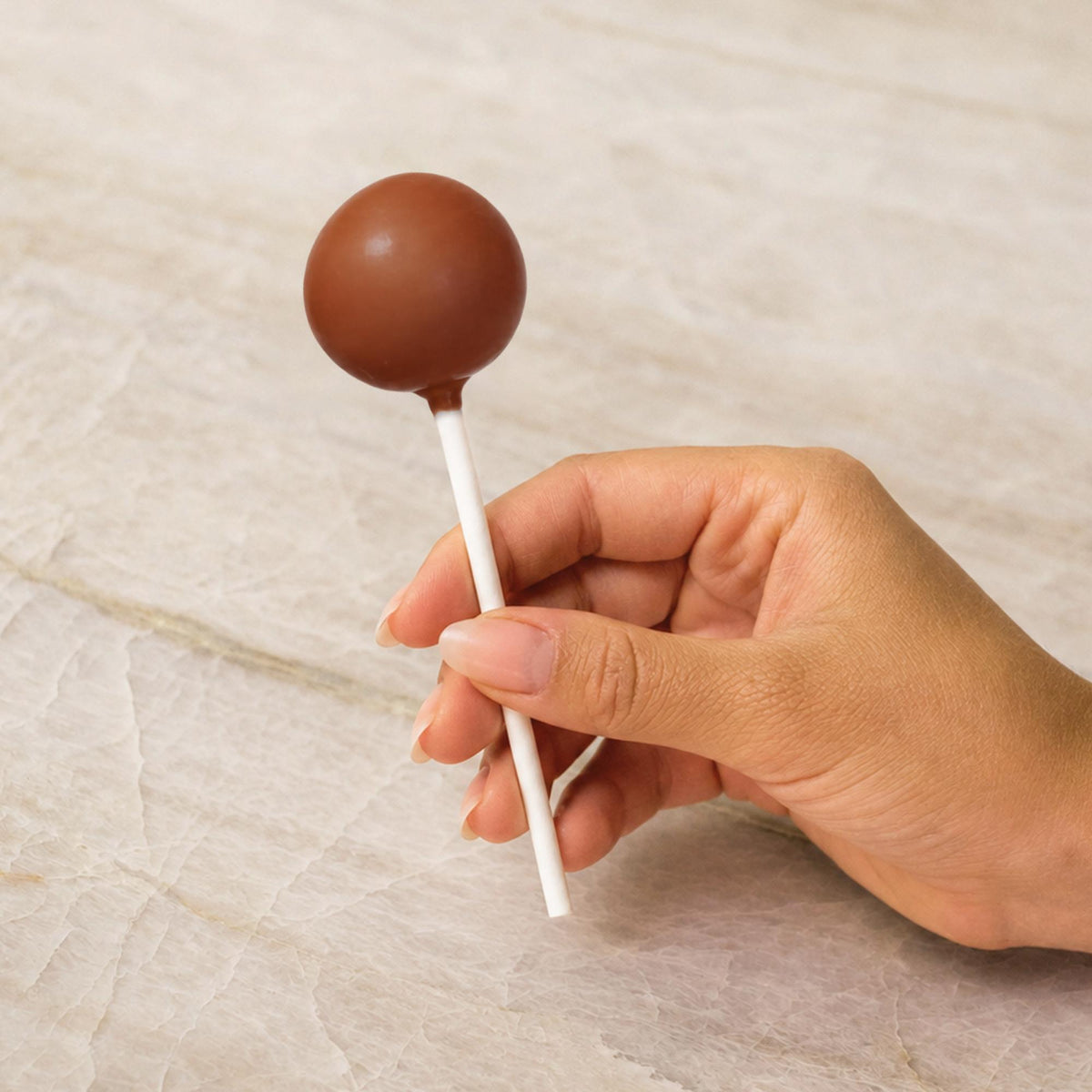 Brown chocolate-coated cake pop made with natural food coloring powder.