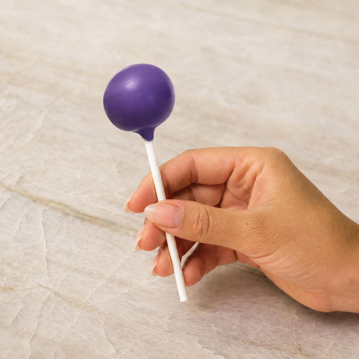Purple chocolate-coated cake pop made with natural food coloring powder.