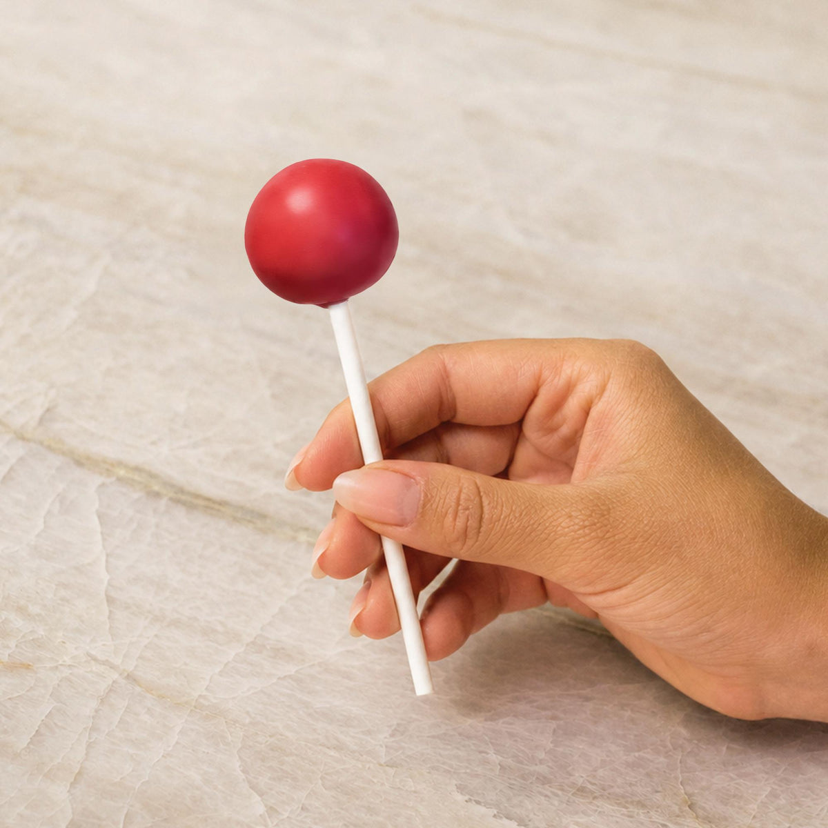 Red chocolate-coated cake pop made with natural food coloring powder.