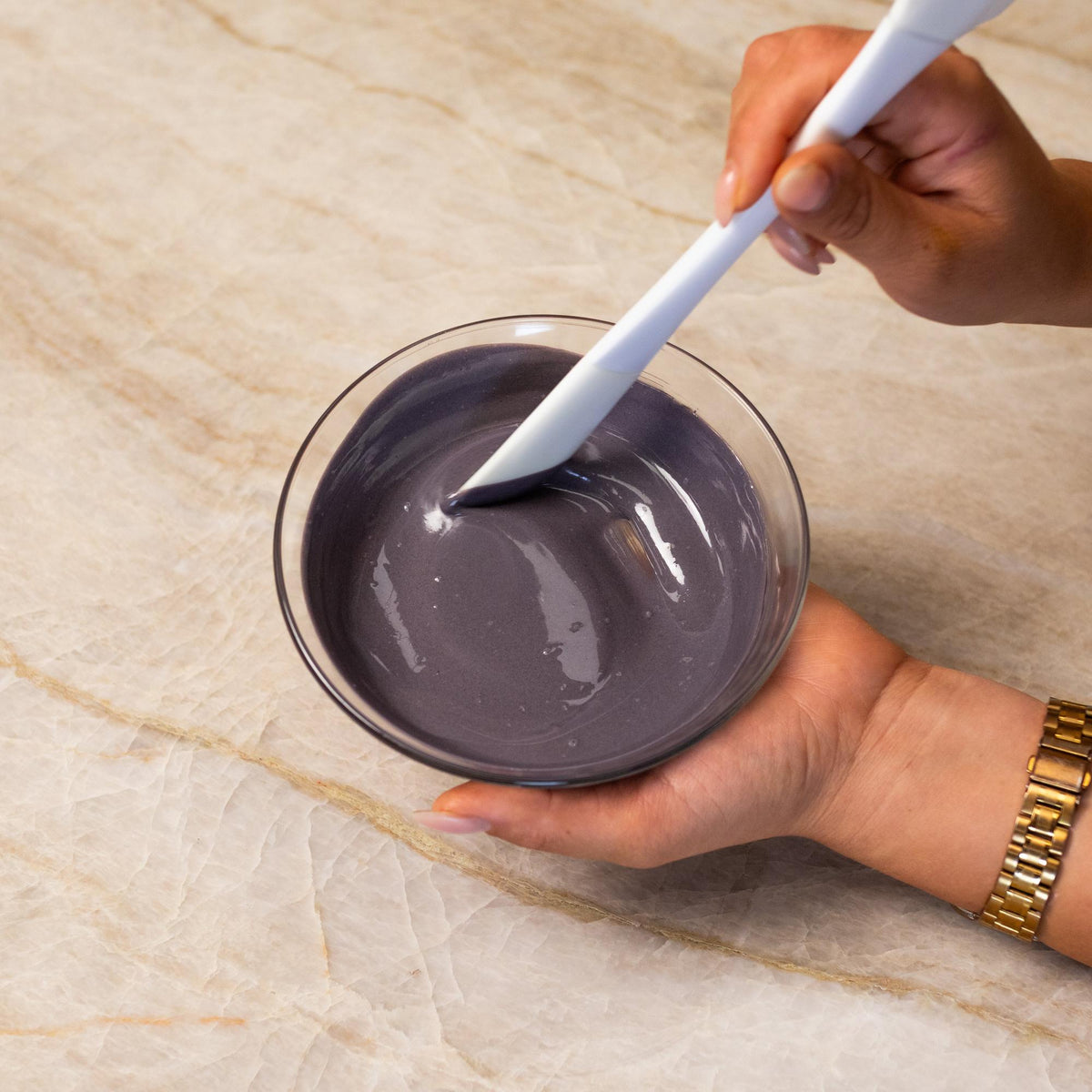 Black chocolate mixed with natural food coloring powder in a bowl.