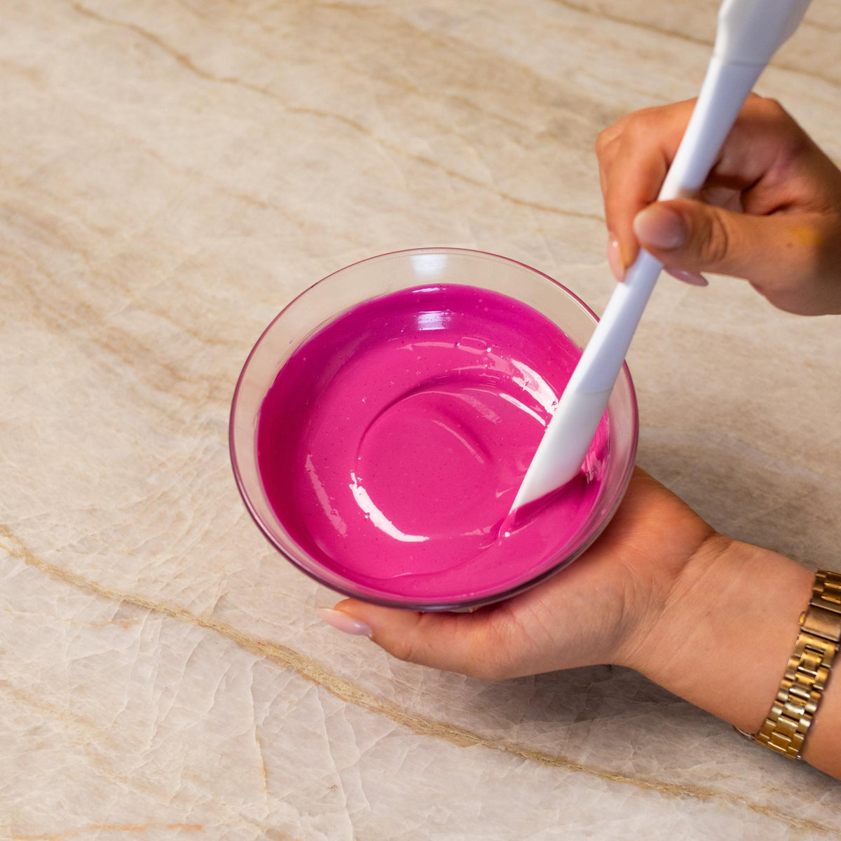 Pink chocolate mixed with natural food coloring powder in a bowl.