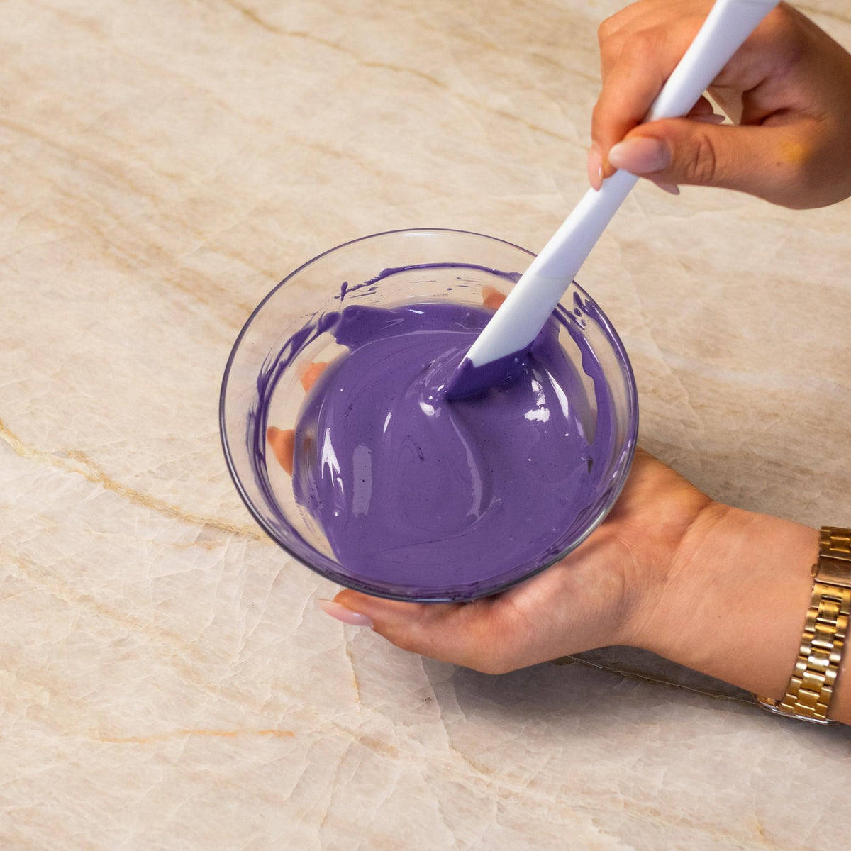 Purple chocolate mixed with natural food coloring powder in a bowl.