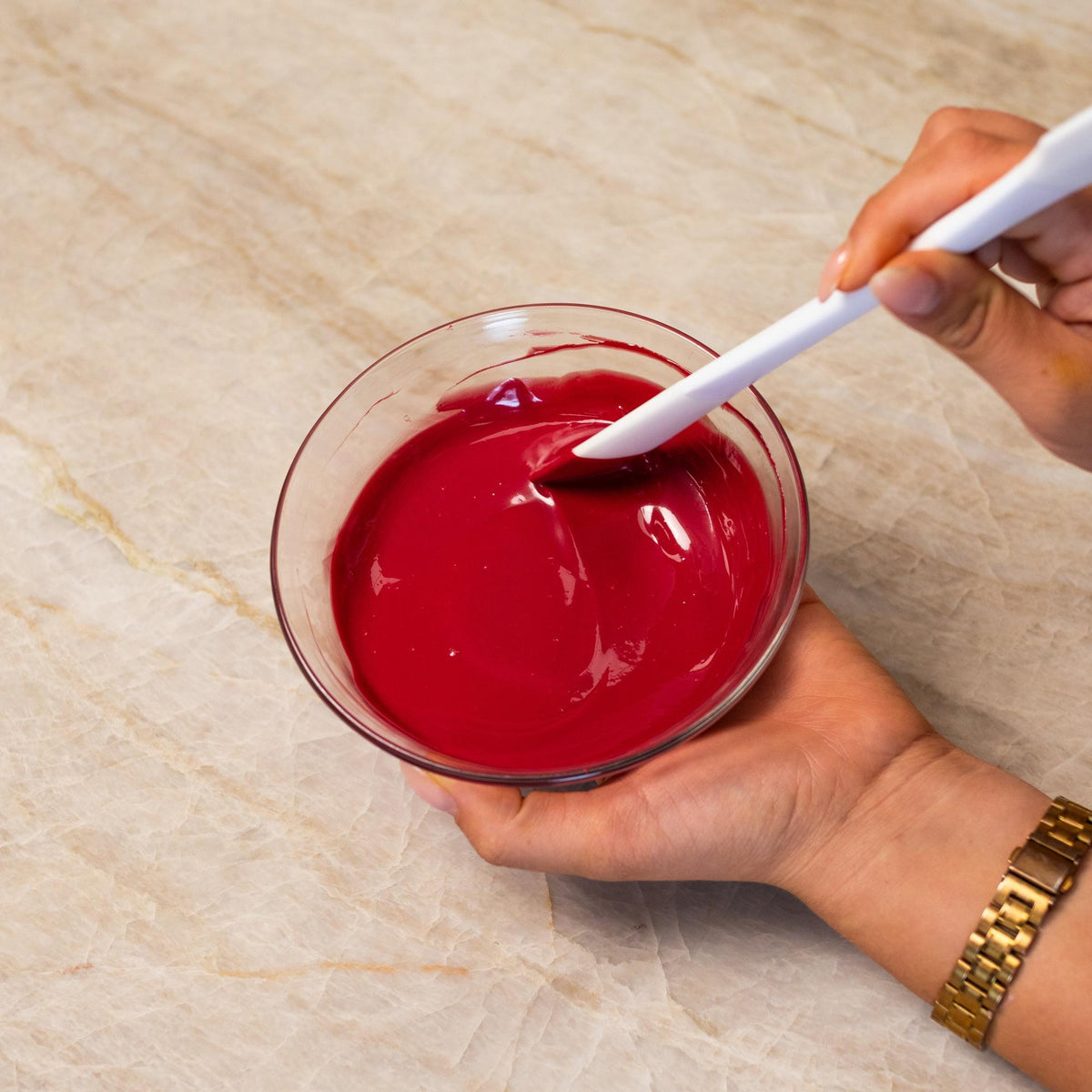 Red chocolate mixed with natural food coloring powder in a bowl.