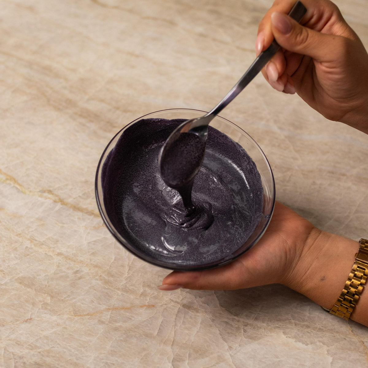 Black cake batter mixed with natural food coloring powder in a bowl.