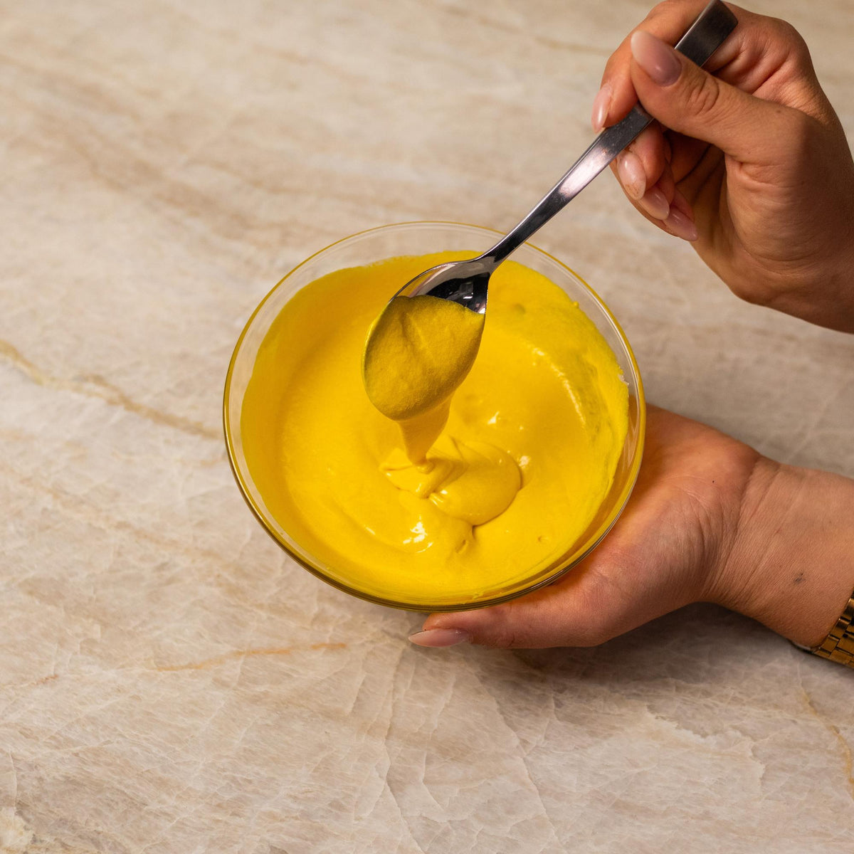 Yellow cake batter mixed with natural food coloring powder in a bowl.