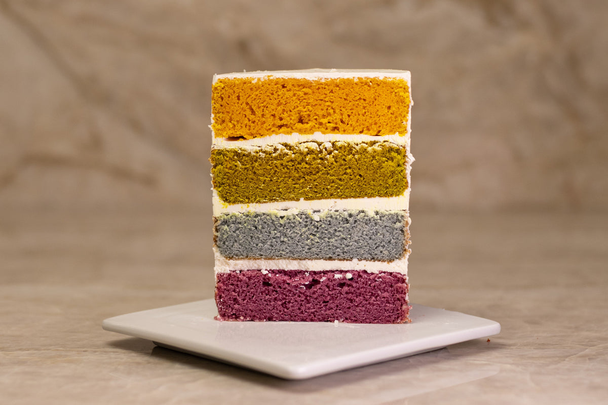A 4-layer cake color comparison with yellow, green, blue, and red natural food coloring. 