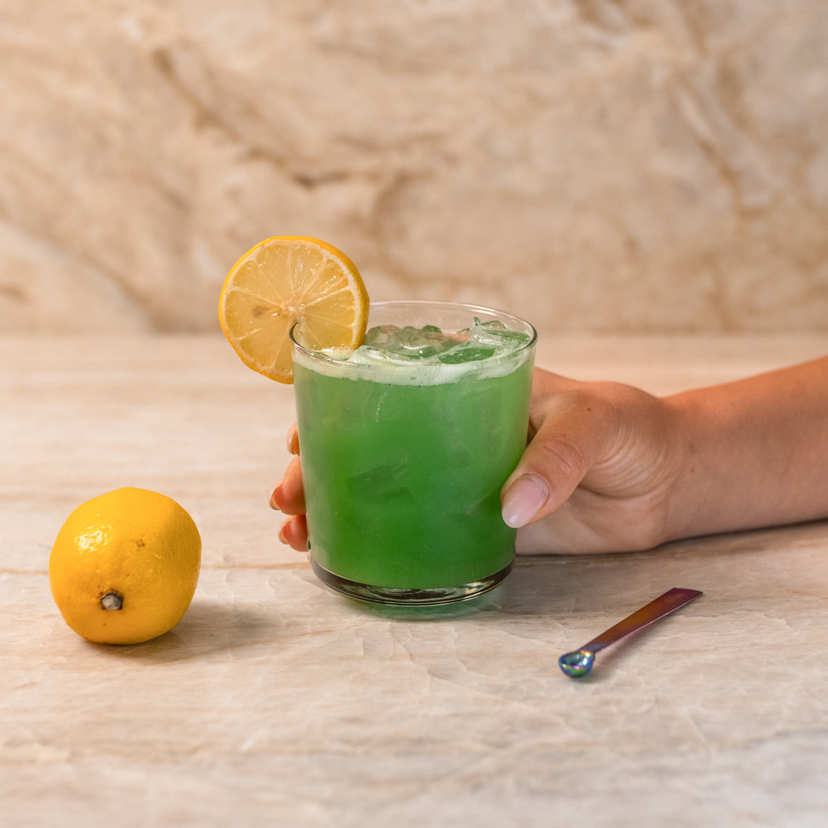 Finished green drink made with ADAMA natural food coloring powder and garnished with lemon.