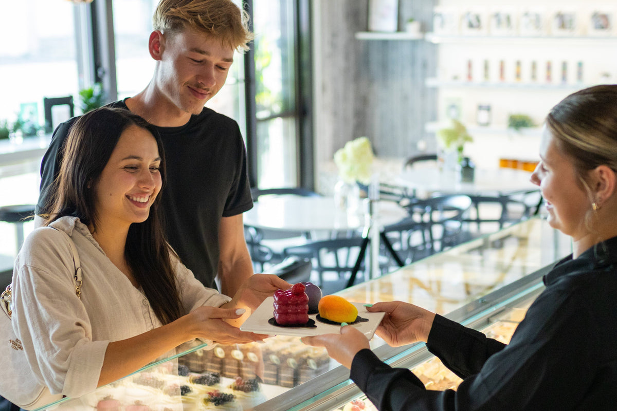 Customers receiving colorful bakery desserts made with ADAMA natural food coloring.