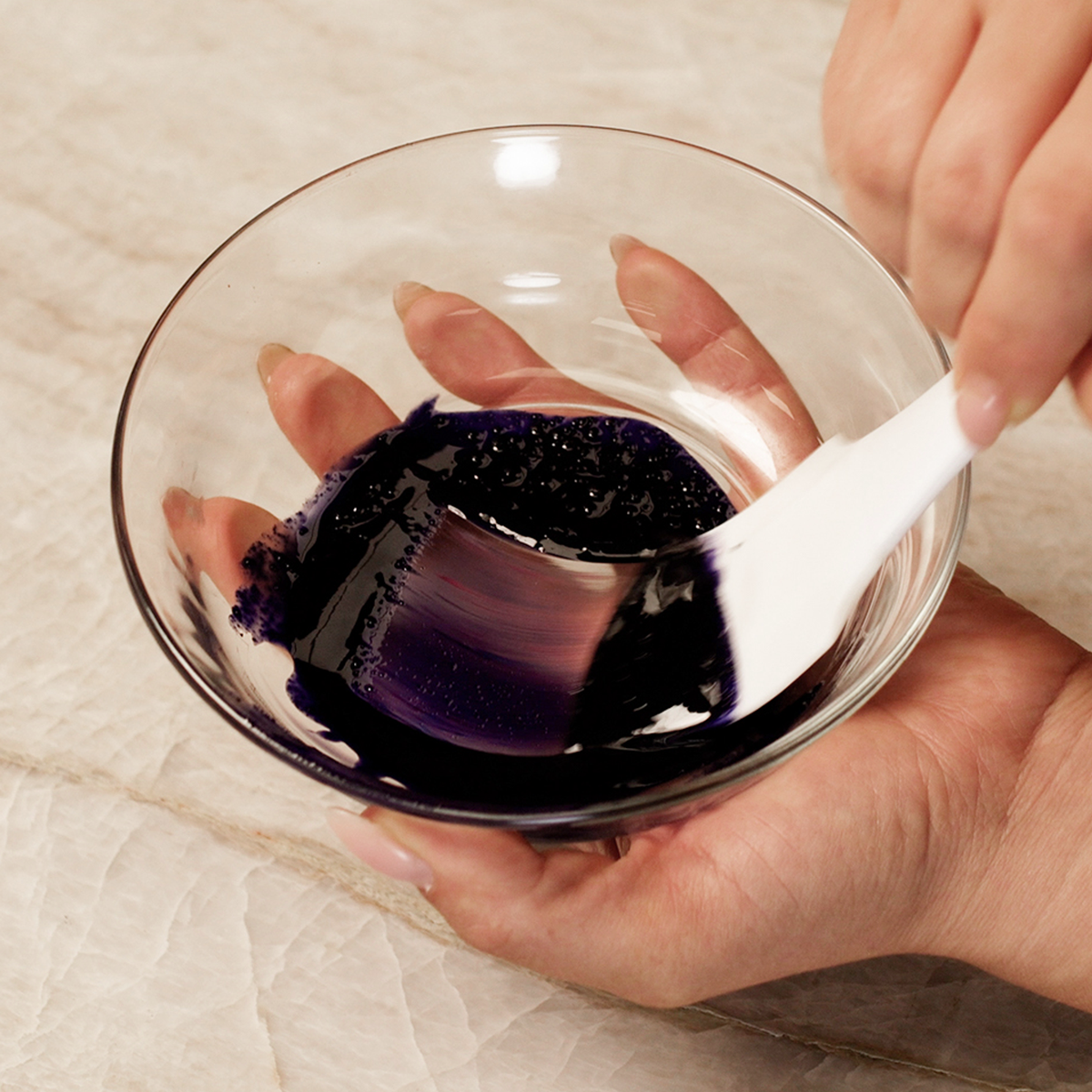 Purple ADAMA natural food coloring powder being mixed into chocolate.
